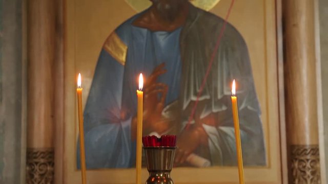 Burning candles and lamp at icon in Church during the Liturgy