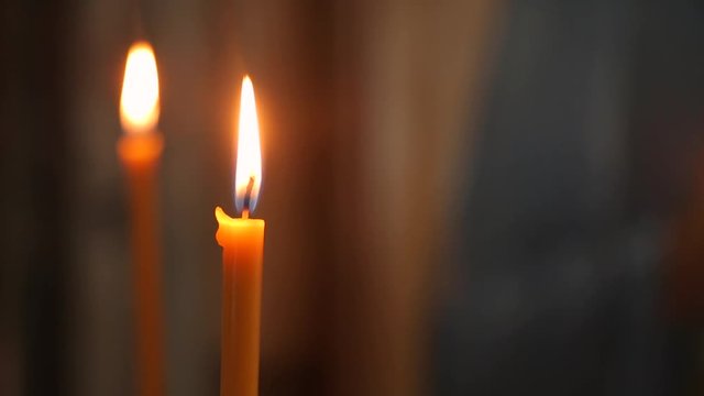 Candle flame close-up on blurred background image of icon in Church