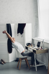 young transgender man stretching while working at home