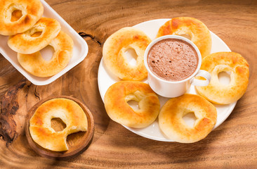 Pandequeso traditional Colombian food - Hot drink chocolate. Wood background