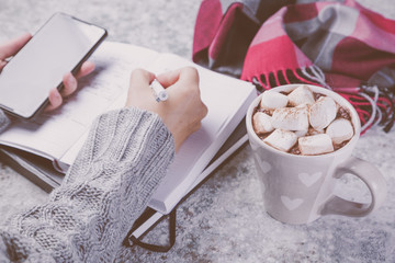Winter cozy workspace with computer, phone, notepad, cocoa copy space