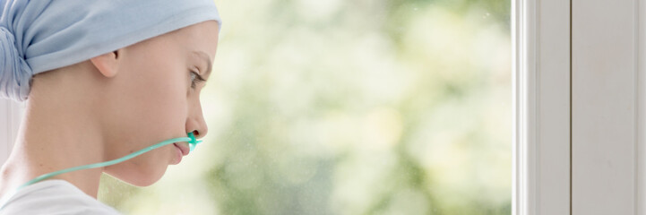 Panorama of weak and sick kid with drip wearing blue headscarf during chemotherapy © Photographee.eu