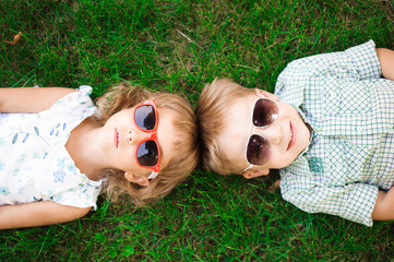Smiling kids at the garden in sunglasses