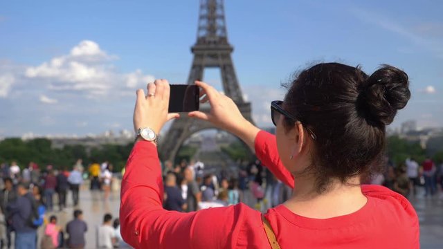 Woman taking picture of Eiffel Tower using smartphone in slow motion 180fps