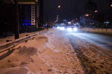 Snowy road with night traffic. City night.