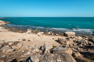 Rocky sea coast with turquoise water on the beach