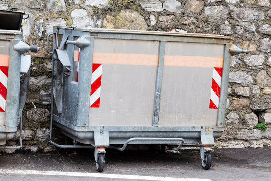 Dump garbage bin on street  near concret wall for waste