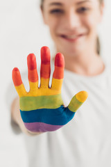 close-up shot of transgender man showing hand painted in colors of pride flag at home