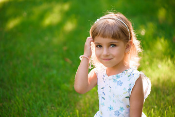 Fototapeta premium Portrait of a beautiful young little girl in summer park