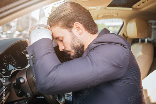Tired And Exhausted Young Businessman Sits On Car Leans To Tired And Exhausted Young Businessman Sits On Car Leans To Steering Wheel He Keeps Eyes Closed Man Sleeping