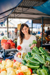 Beautiful casual woman buying groceries at local market.