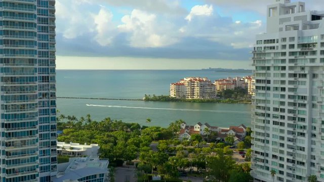 Aerial drone video between highrise buildings reveal Fisher Island and inlet