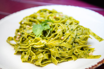 Pasta with pesto sauce and nuts on a the table