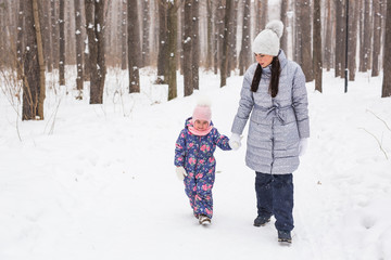 Motherhood, children and nature concept - Attractive young woman and adorable child walking in park