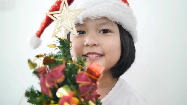 4K : Happy lovely Asian girl putting ornament on Christmas tree and showing all together