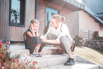 Emotional girl. Caring father talking to his little daughter feeling emotional on first day at school