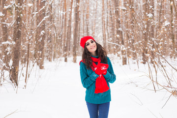 Fototapeta na wymiar Young pretty woman walking in the winter snowy park at sunny day