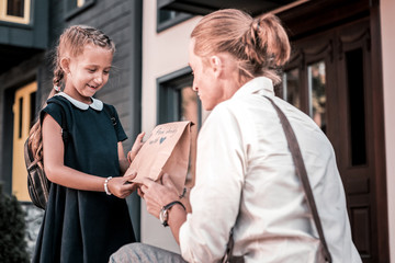 Obraz premium Birthday presents. Dark-haired smiling schoolgirl feeling extremely happy while receiving birthday presents