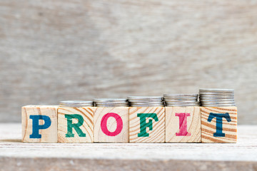 Letter block in word profit on wood background with coin stack in up trend (Concept for revenue,...