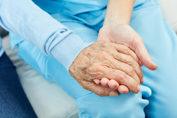Krankenschwester hält Hand einer Seniorin