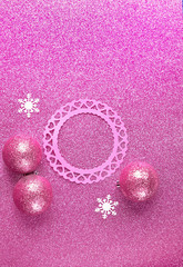 Christmas holiday background. festive winter season. snowflakes, Christmas balls and paper frame on pink glitter abstract background. copy space. top view. template for design