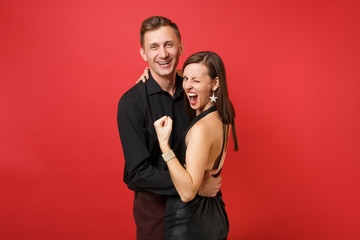 Fashionable young couple in black clothes shirt dress celebrating birthday holiday party isolated on bright red background. St. Valentine International Women Day Happy New Year 2019 concept. Mock up.