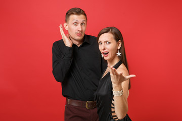 Fun expression young couple in black clothes shirt dress celebrating birthday holiday party isolated on bright red background. St Valentine International Women Day Happy New Year 2019 concept. Mock up