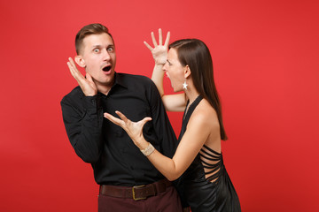 Fun expression young couple in black clothes shirt dress celebrating birthday holiday party isolated on bright red background. St Valentine International Women Day Happy New Year 2019 concept. Mock up