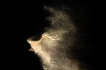 Dry river sand explosion. Golden colored sand splash against  black background.