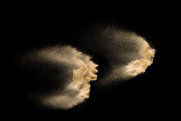 Dry river sand explosion. Golden colored sand splash against  black background.