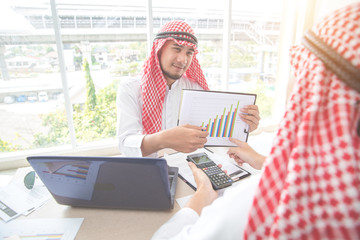 arab saudi businessman working and discussing with graph and calculator in office