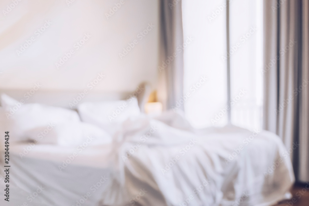 Poster blurred comfortable bedroom with sun light ,messy bedding sheets and duvet with wrinkle messy in the