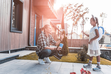 Angel costume. Cute dark-haired daughter wearing angel costume coming to her handsome father