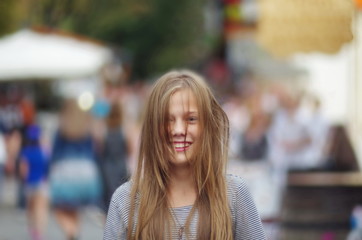 Portrait of a teenage girl on a background of people in a big city. A teenage girl in a crowd of people.