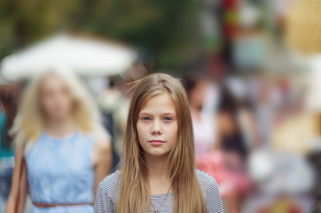 Portrait of a teenage girl on a background of people in a big city. A teenage girl in a crowd of...