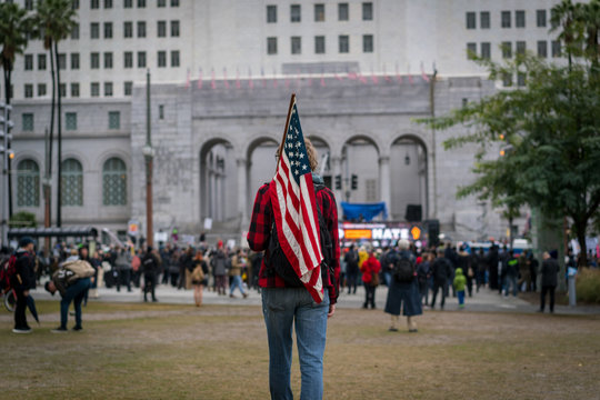A young man carries an American flag to a protest