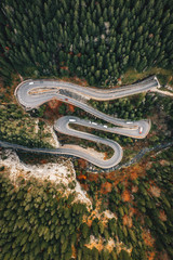 Top-down view of an extreme curved winding road in the middle of a forest