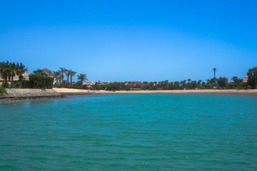 Fototapeta premium Beautiful view of the coastline with houses and hotels on the red sea. Tourist region in Egypt. Hurghada and its traditions. Stock photo for design