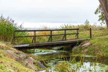 Tr&auml;bro &ouml;ver en kanal vid havet
