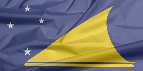 Fabric flag of Tokelau. Crease of Tokelau flag background, A light blue field with the large yellow disk shifted slightly to the hoist-side of center. - Powered by Adobe