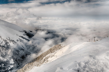 Fototapeta na wymiar Winter Alpine snowpeak background with ountainous terrain and snow covered trees texture. Bansko, Bulgaria