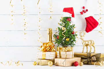 Winter composition with Christmas gift or present boxes, fir tree and golden holiday decorations on wooden background.