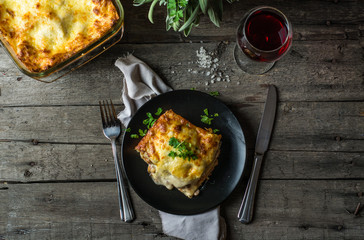 Piece of tasty hot lasagna with red wine. Small depth of field. Traditional italian lasagna....