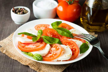 Close-up photo of caprese salad with ripe tomatoes, basil, buffalo mozzarella cheese. Italian and Mediterranean food concept. Fresh and healthy organic meal. Starter and antipasti. 