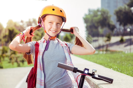 Like fox. Pretty teenager standing near push-cycle while looking aside