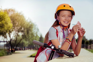 Fototapeta na wymiar Little model. Kind little female expressing positivity while having break