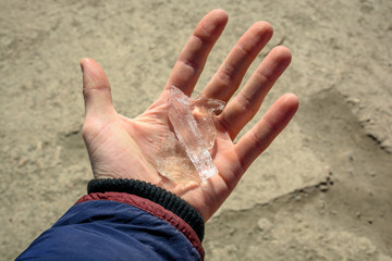 Male hand holds the ice. Weather change. Winter is coming