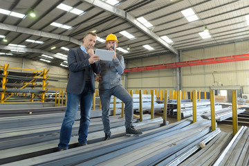two managers workers in warehouse with tablet computer
