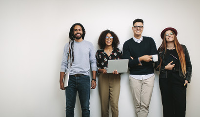 Businessman holding a coffee cup standing with coworkers in offi