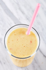 Smoothie. A glass full of refreshing healthy milk smoothie made from various fruit. Banana, apple.